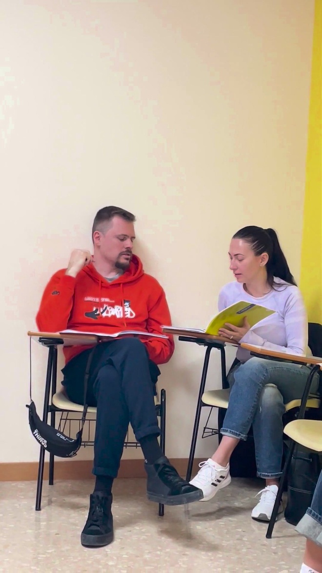 A teacher and a student reading the textbook together in class