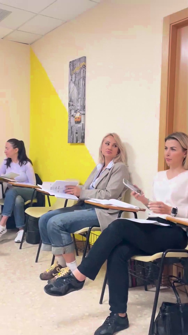A three-person Spanish mini-group in the classroom with the yellow wall