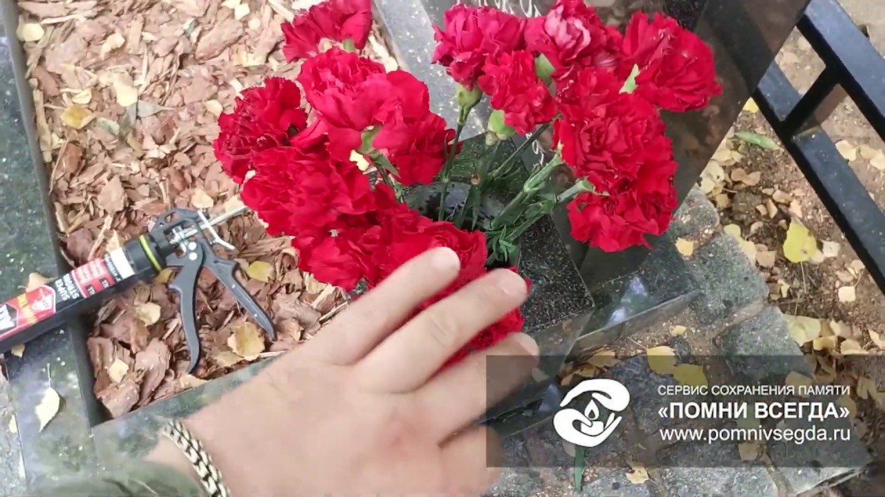Размещение живых цветов в квадратной вазе на могиле